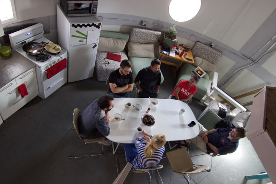 Mars 160 crewmembers chat around a table at the Mars Desert Research Station. <cite>The Mars Society</cite>