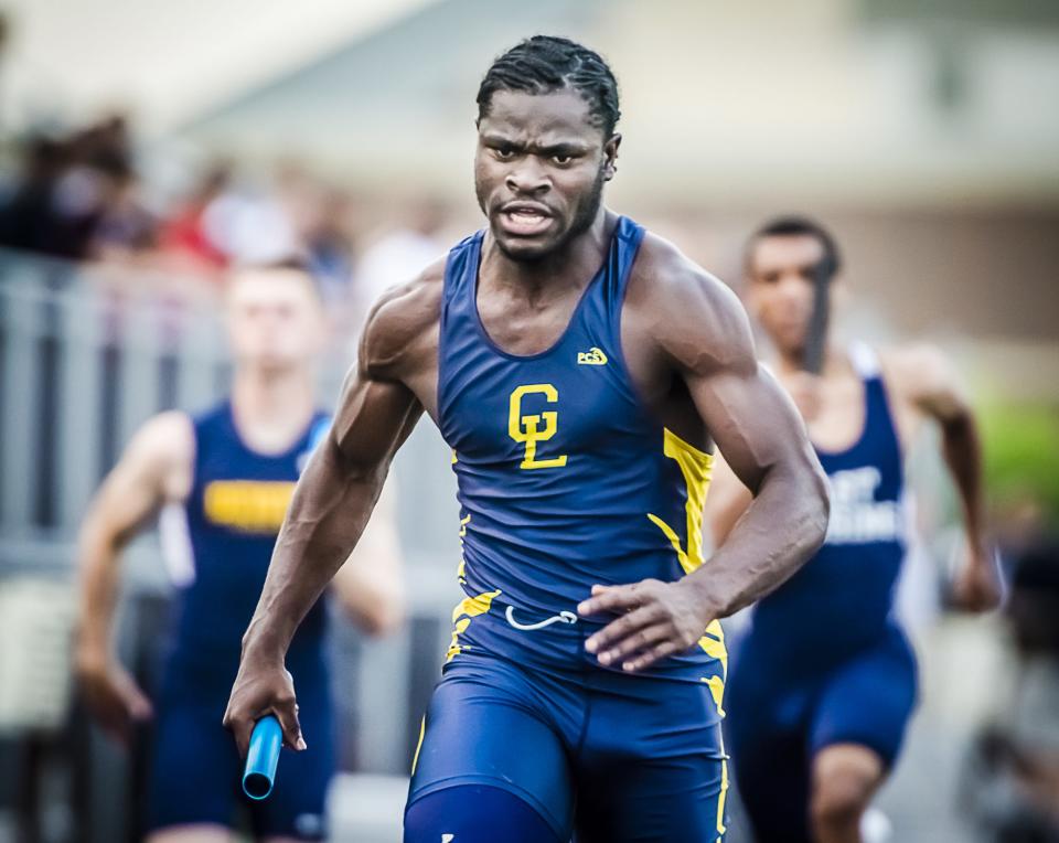 Ba Blamo of Grand Ledge helps his team to a first place finish in the final heat of the 4X100 meter relay at the Honor Roll Track Meet in 2013 in Holt.