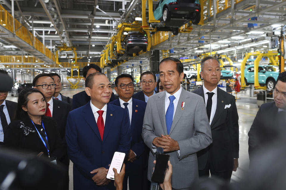 In this photo released by VinFast, Indonesian President Joko Widodo, center right, speaks with Vingroup Chairman and VinFast Global CEO Pham Nhat Vuong, center left, after visiting VinFast EV manufacturing complex in Hai Phong, Vietnam on Saturday, Jan. 13, 2024. (VinFast via AP)