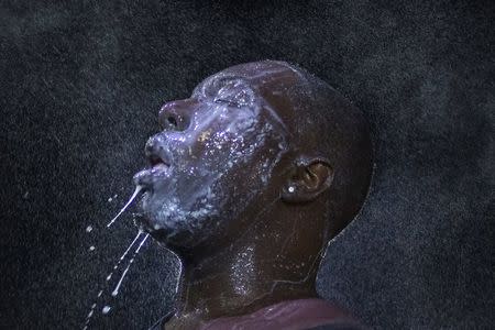 A man is doused with milk and sprayed with mist after being hit by an eye irritant from security forces trying to disperse demonstrators protesting against the shooting of unarmed black teen Michael Brown in Ferguson, Missouri, in this August 20, 2014 file photo. REUTERS/Adrees Latif/Files