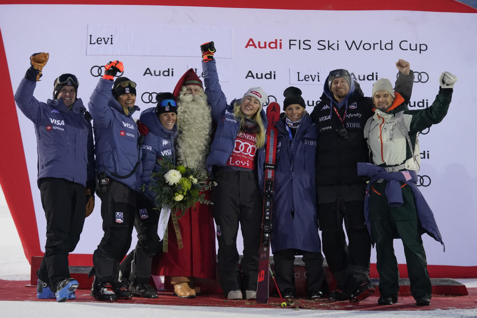 United States' Mikaela Shiffrin celebrates with her team after winning an alpine ski World Cup women's slalom race, in Levi, Finland, Sunday, Nov. 12, 2023. (AP Photo/Giovanni Auletta)