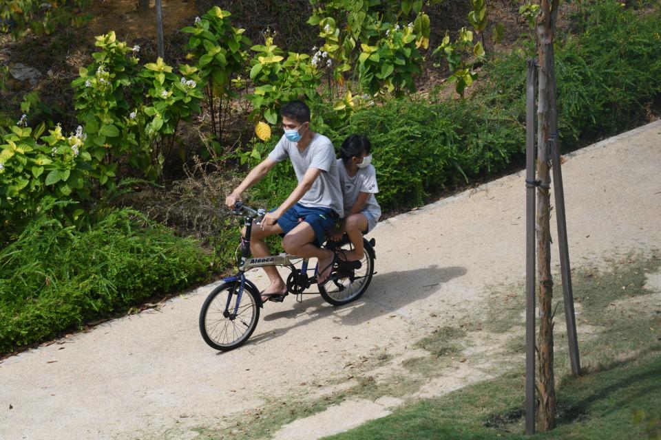 A man cycles with his daughter along a neighbourhood housing estate in Singapore on August 10, 2020. (Photo by Roslan RAHMAN / AFP) (Photo by ROSLAN RAHMAN/AFP via Getty Images)