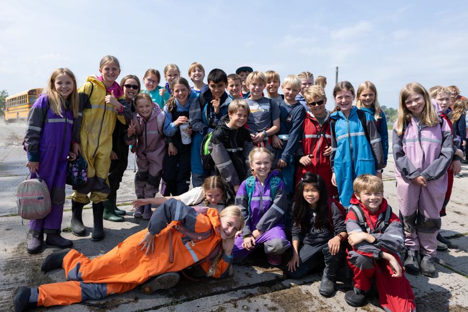 Fourth-graders from Holland Christian's Forest School pose for a photo before releasing salmon into the Kalamazoo River on May 16, 2024.