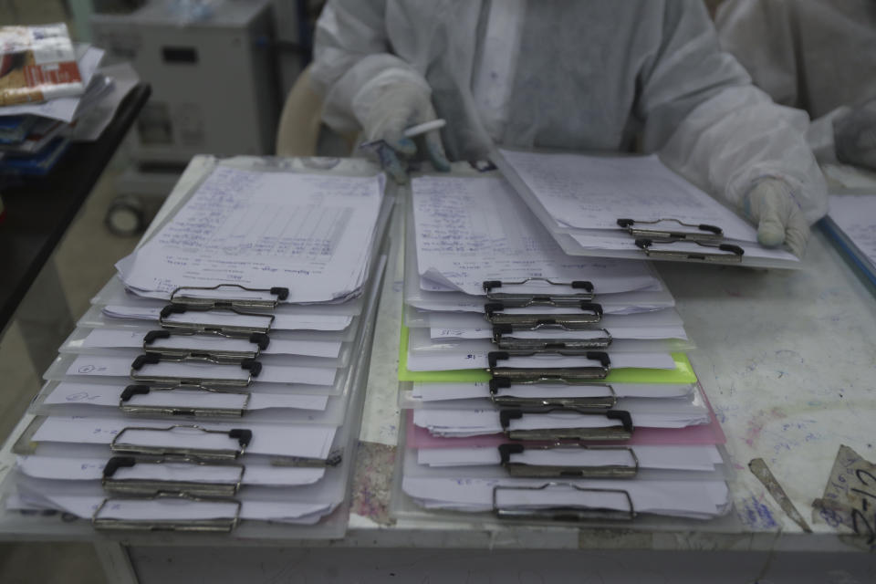 A health worker looks over patient files at the BKC jumbo field hospital, one of the largest COVID-19 facilities in Mumbai, India, Friday, May 7, 2021. (AP Photo/Rafiq Maqbool)