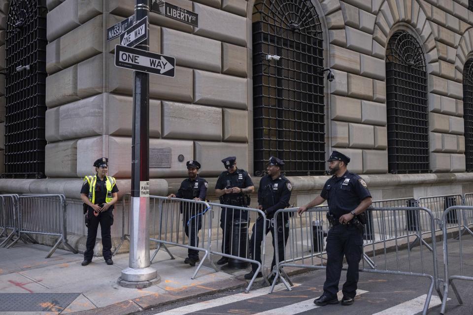 Police officers stand outside an Attorney General's office building for depositions in a civil investigation in New York, Thursday, April. 13, 2023. Former President Donald Trump is expected to visit the offices of New York’s attorney general for his second deposition in a legal battle over his company’s business practices. (AP Photo/Yuki Iwamura)