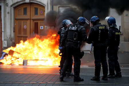 FILE PHOTO: French Gendarmes stand near a fire during a demonstration of the "yellow vests" movement in Strasbourg, France, January 12, 2019. REUTERS/Vincent Kessler/File Photo