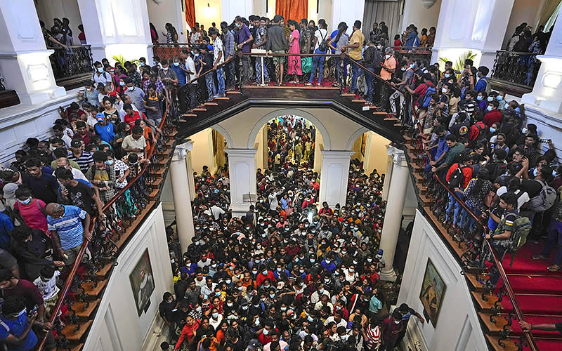 People throng President Gotabaya Rajapaksa’s official residence for the second day after it was stormed in Colombo, Sri Lanka, on July 11. Sri Lanka is in a political vacuum for a second day with opposition leaders yet to agree on who should replace its roundly rejected leaders, whose residences are occupied by protesters angry over the country’s economic woes. <em>Associated Press/Eranga Jayawardena</em>