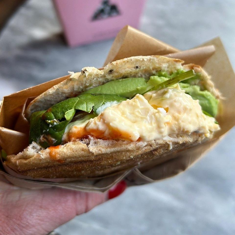 Eggcado breakfast sandwich with avocado, egg ‘mousse’, spinach, tomato and sriracha sauce