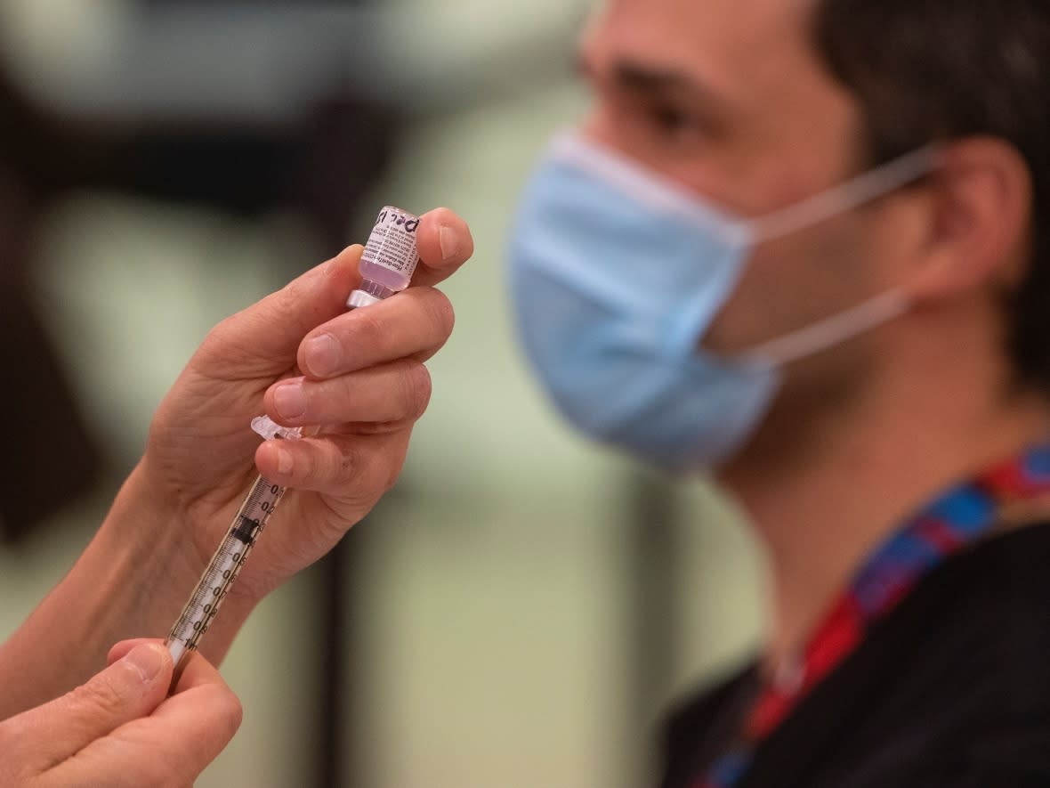 A nurse prepares to give a COVID-19 vaccine in Edmonton, to Castro Arian in Edmonton Alta, on Tuesday December 15. (Jason Franson/The Canadian Press - image credit)