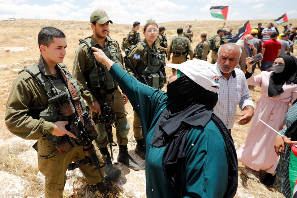 Image: Palestinians argue with Israeli soldiers  (Mussa Qawasma / Reuters)