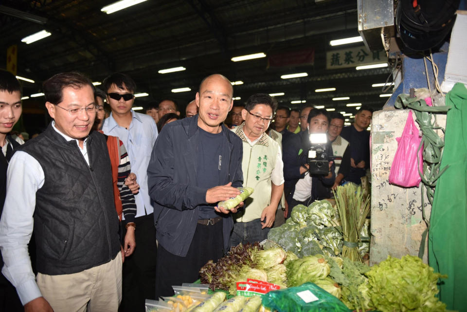 韓國瑜巡果菜市場關心拍賣上任即夜宿高雄十全果菜市場的高雄市長韓國瑜（前左2），26日凌晨起床巡視果菜拍賣作業，攤商與粉絲紛 紛要求合照，被考問菜名都難不倒。（翻攝照片）