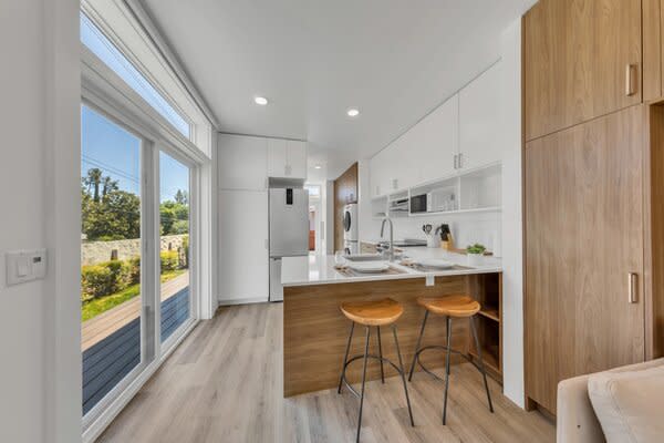 A sliding glass door beside the kitchen provides additional entry into the home from a wraparound deck.