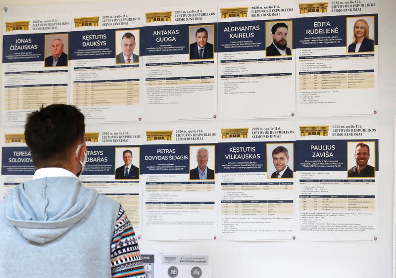 A man looks at candidates posters in a polling station during general election in Trakai