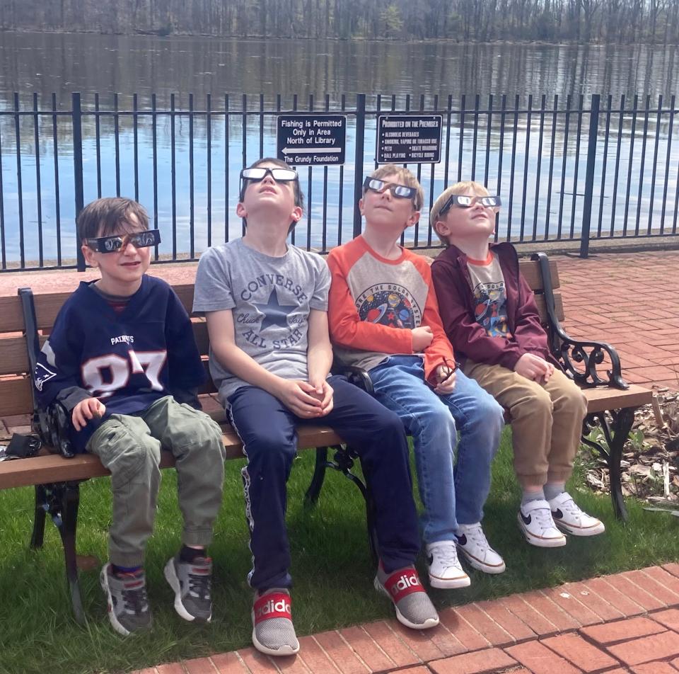 Testing eclipse glasses (L to R): Otis Errickson, 6, Tucker Leonard, 9, Ben Gallagher, 8, and Sam Gallagher, 6, of Croydon, test their solar eclipse glasses at the Margaret R. Grundy Memorial Library in Bristol on April 8, 2024.