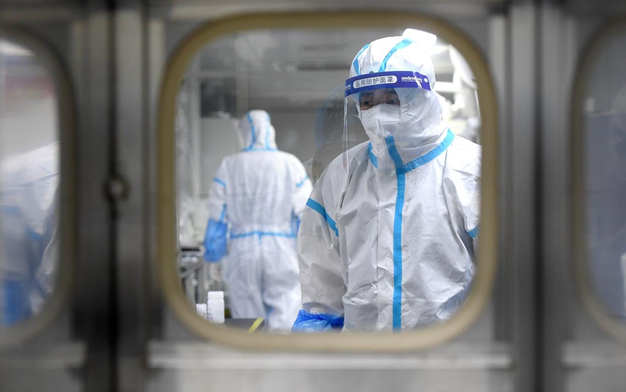 Medical workers in protective suits test nucleic acid samples inside a Huo-Yan (Fire Eye) laboratory of BGI,