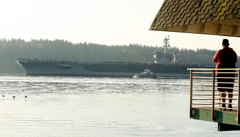 The USS Theodore Roosevelt (CVN-71) passes Bachmann Park in Bremerton, Wash. as the aircraft carrier departs Puget Sound Naval Shipyard after its 18-month overhaul, on Friday, March 17, 2023.