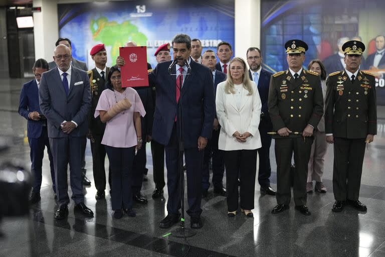 El presidente de Venezuela, Nicolás Maduro, sostiene un folleto con su nombre mientras habla con la prensa en el Tribunal Supremo en Caracas, Venezuela, miércoles 31 de julio de 2024, tres días después de su disputada reelección. (AP Photo/Fernando Vergara)