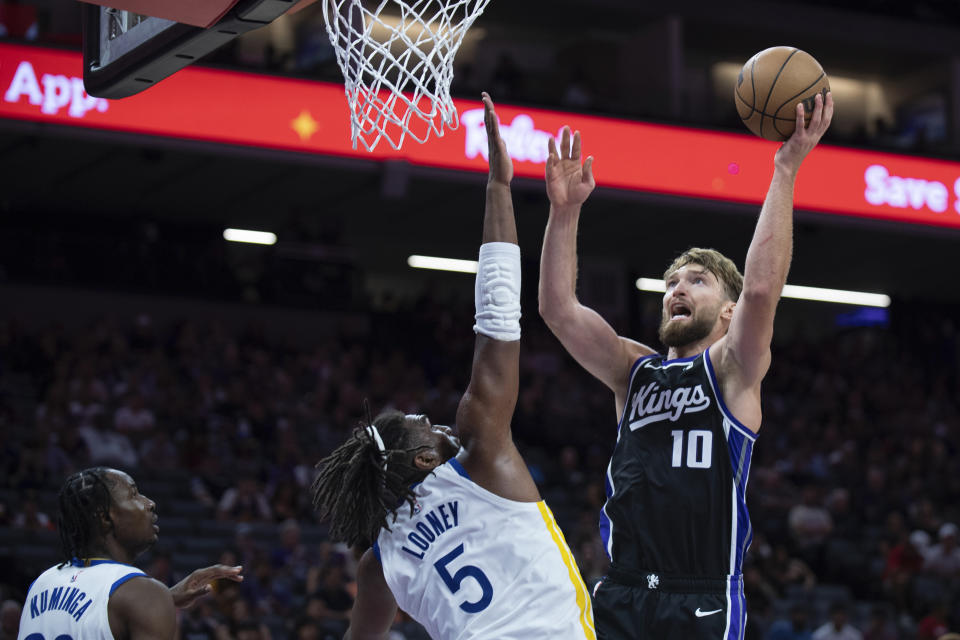 Sacramento Kings forward Domantas Sabonis (10) shoots over Golden State Warriors forward Kevon Looney (5) in the second half of a preseason NBA basketball game in Sacramento, Calif., Sunday, Oct. 15, 2023. The Warriors won 121-115. (AP Photo/José Luis Villegas)