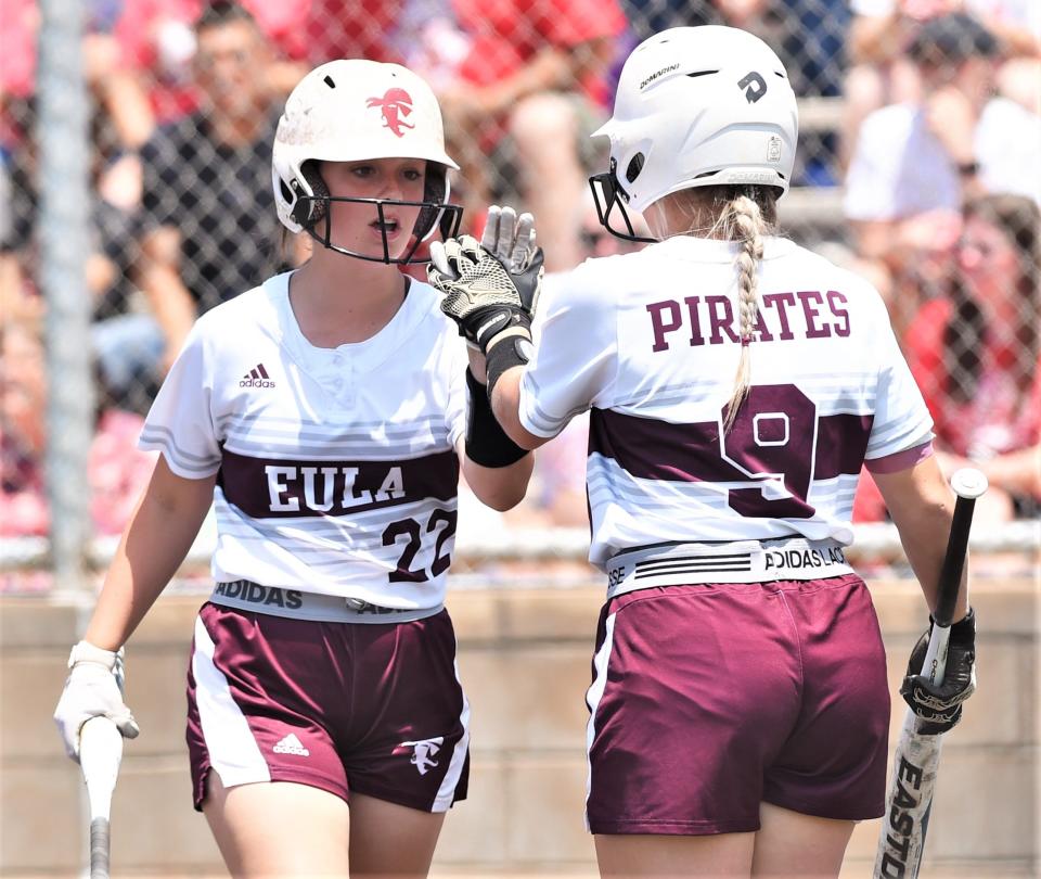 Eula's Layla Fostel, left, is congratulated by Avery Meers after scoring CaLece Coats' single in the sixth inning against Hermleigh.