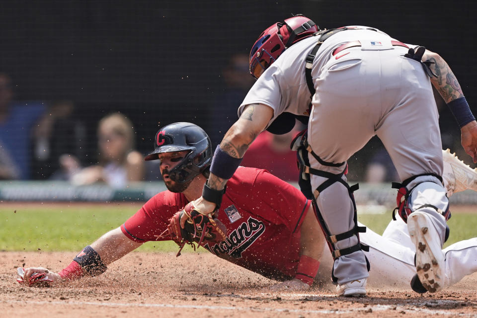 Cleveland Indians' Austin Hedges scores as St. Louis Cardinals' Yadier Molina is late on the tag in the fourth inning of a baseball game, Wednesday, July 28, 2021, in Cleveland. (AP Photo/Tony Dejak)