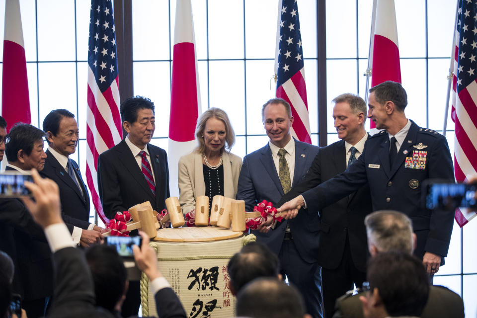 From left; Japan's Foreign Minister Toshimitsu Motegi, deputy prime minister Taro Aso, Prime Minister Shinzo Abe, granddaughter Mary Jean Eisenhower and the great grandson Merrill Eisenhower Atwater of former U.S. President Dwight Eisenhower, acting U.S. Ambassador to Japan Joseph M. Young and Commander of the U.S. Forces in Japan Lieutenant General Kevin Schneider break a barrel of sake to celebrate the 60th anniversary commemorative reception of the signing of the Japan-US security treaty at the Iikura Guesthouse in Tokyo, Sunday, Jan. 19, 2020. (Behrouz Mehri)