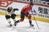 Washington Capitals right wing Tom Wilson (43) skates with the puck past Boston Bruins defenseman Jack Ahcan (54) during the second period of an NHL hockey game, Tuesday, May 11, 2021, in Washington. (AP Photo/Nick Wass)