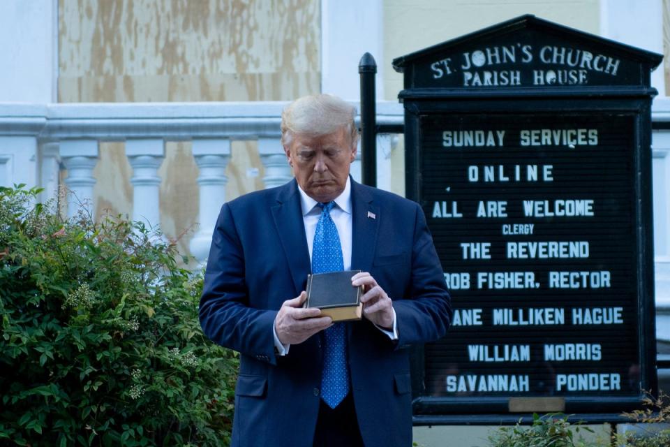 Donald Trump holds a Bible as he visits St. John's Church across from the White House after the area was cleared of people protesting the death of George Floyd June 1, 2020, in Washington, DC (AFP via Getty Images)