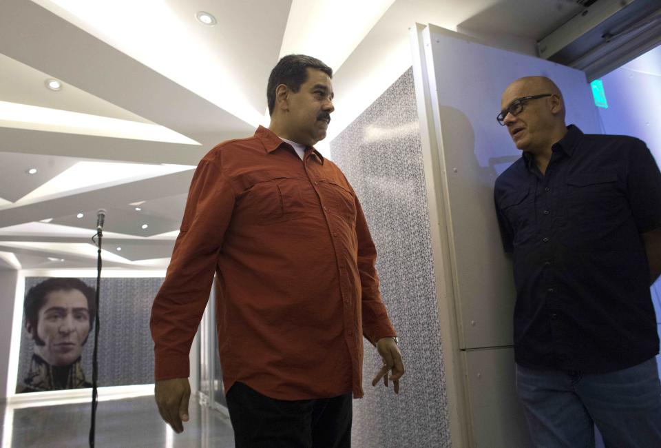 FILE - In this April 5, 2018 file photo, Venezuela's President Nicolas Maduro, left, speaks with his press officer Jorge Rodriguez, in Caracas, Venezuela. The Trump administration slapped financial sanctions on Tuesday, Sept. 25, 2018, on four members of Maduro’s inner circle, including his wife, the nation’s vice president and Rodriguez, on allegations of corruption. (AP Photo/Ariana Cubillos, File)