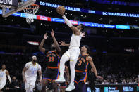 Los Angeles Lakers guard Malik Beasley, top center, scores past New York Knicks center Mitchell Robinson (23) and guard Trevor Keels (3) during the first half of an NBA basketball game Sunday, March 12, 2023, in Los Angeles. (AP Photo/Marcio Jose Sanchez)