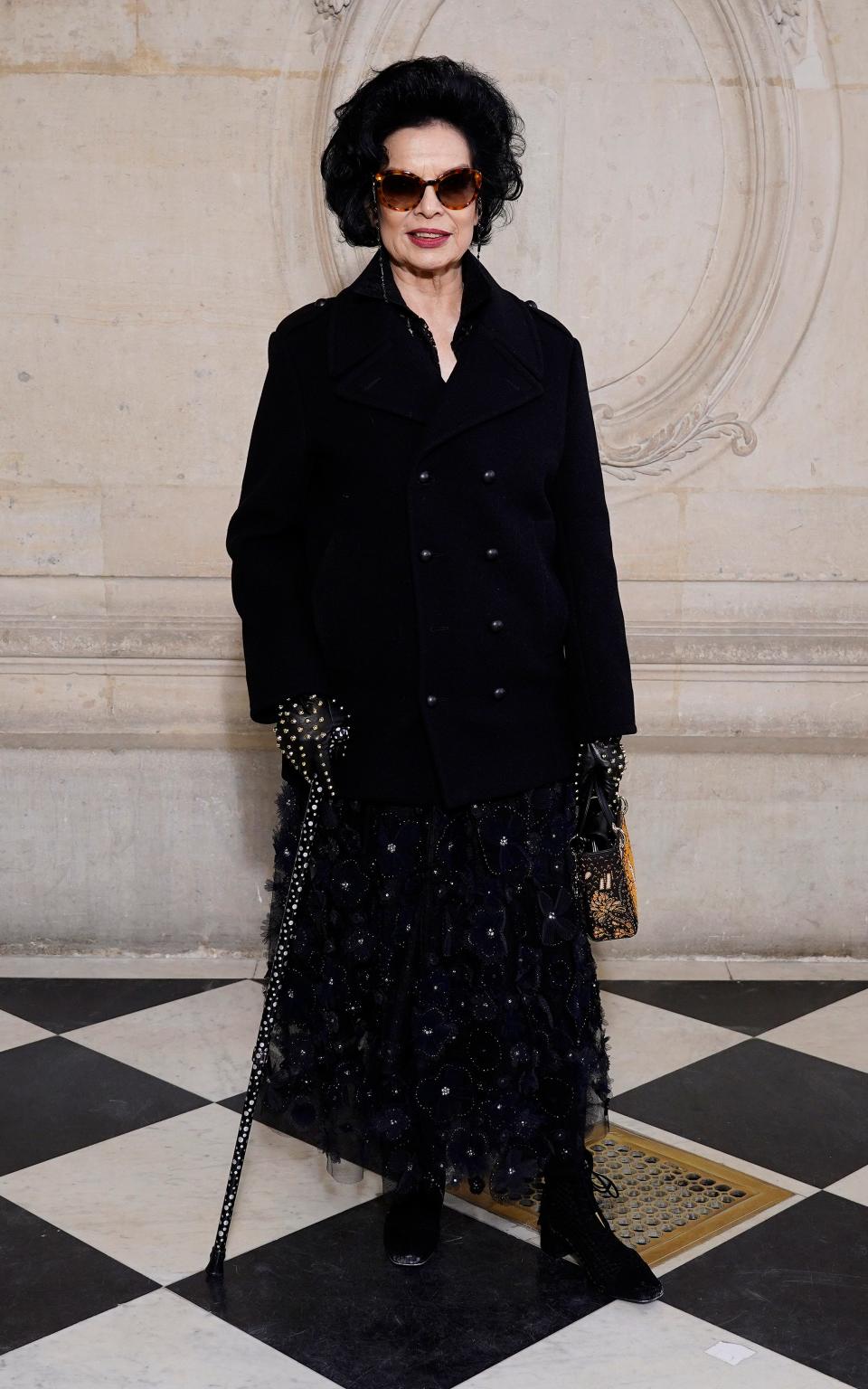 Bianca Jagger wears a black look designed by Maria Grazia Chiuri for the spring/summer 2020 Couture show in Paris - Getty