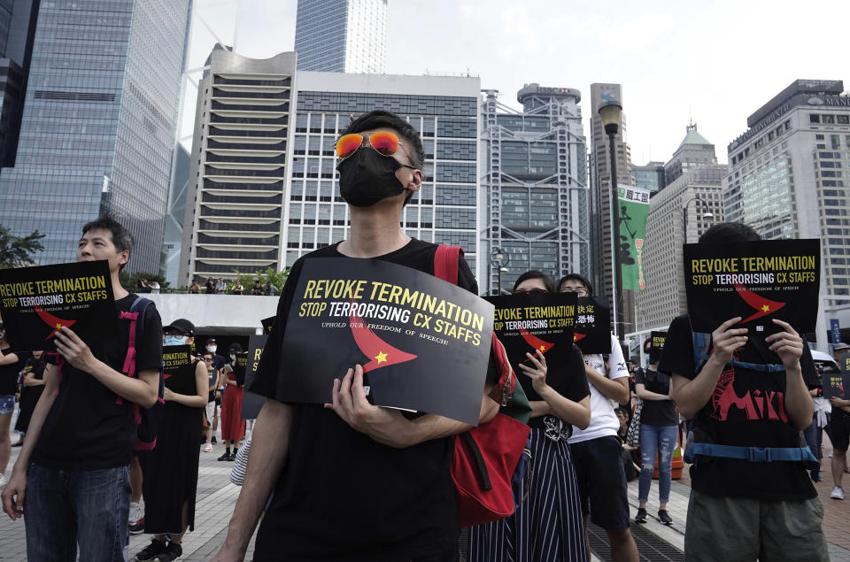 Demonstrators hold signs opposing the recent firings of Cathay Pacific employees as they gather for a demonstration in Hong Kong, Wednesday, Aug. 28, 2019. Trade union members in Hong Kong are rallying against the city's flagship Cathay Pacific airline for firing employees linked to ongoing pro-democracy protests. (AP Photo/Vincent Yu)