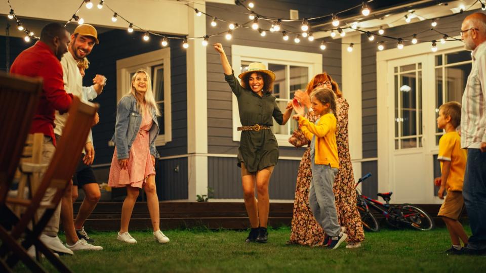 Parents, Children and Friends Dancing Together at a Garden Party under string lights