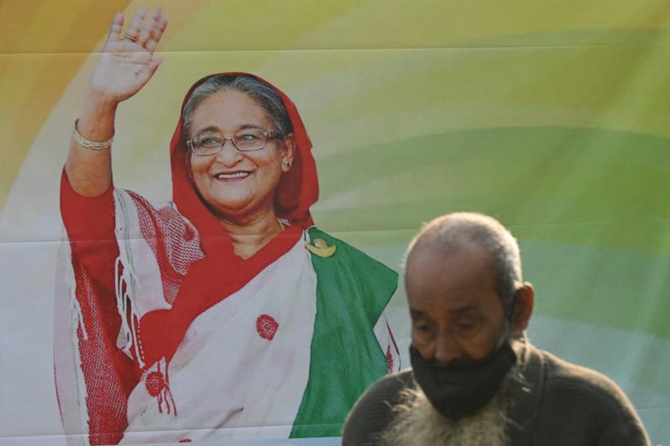 A man walks past a poster of Sheikh Hasina in Dhaka –  Bangladesh’s PM is credited with creating domestic stability following a turbulent past (AFP via Getty Images)