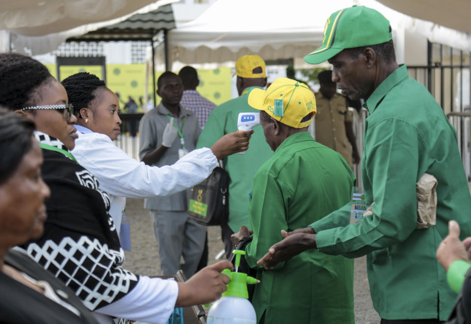 Party members have their temperature checked and sanitize their hands as a precaution against the coronavirus at the national congress of the ruling Chama cha Mapinduzi (CCM) party in Dodoma, Tanzania Saturday, July 11, 2020. Tanzania's ruling party on Saturday nominated President John Magufuli to run for a second five-year term, while opposition parties and human rights groups demand an independent electoral body to oversee the October vote. (AP Photo)