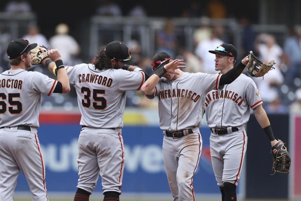 San Francisco Giants' Brandon Crawford (35) and Mike Yastrzemski, second from right, celebrate after the team defeated the San Diego Padres in a baseball game, Wednesday, Oct. 5, 2022, in San Diego. (AP Photo/Derrick Tuskan)