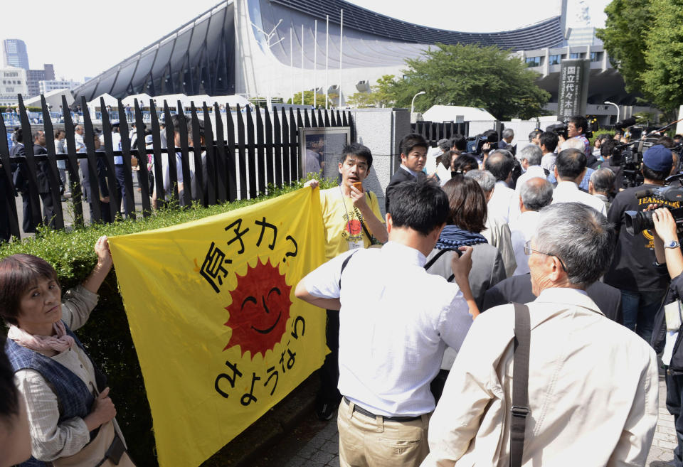 Holding a banner reading: A farewell to nuclear power, anti-nuclear demonstraters appeal to shareholders heading to the venue of Tokyo Electric Power Co.'s shareholders meeting in Tokyo Wednesday, June 27, 2012. The power company behind Japan's nuclear crisis got support from shareholders for its decision to take 1 trillion yen ($12.6 billion) in public funds to cover huge compensation and cleanup costs. But shareholders including the Tokyo city government demanded more restructuring and safety improvements from TEPCO., which operates the tsunami hit Fukushima Dai-ichi nuclear plant.(AP Photo/Kyodo News) JAPAN OUT, MANDATORY CREDIT, NO LICENSING IN CHINA, HONG KONG, JAPAN, SOUTH KOREA AND FRANCE