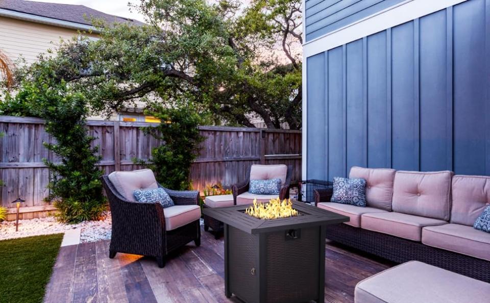 the amazon Propane Fire Pit Table outside with outdoor patio furniture