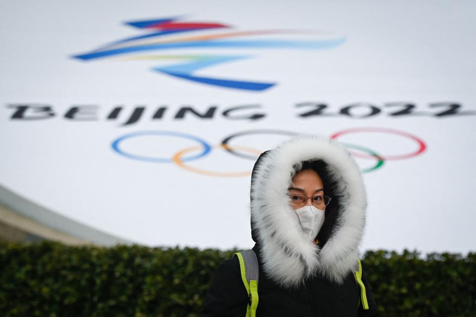 A woman walks past an installation promoting the Beijing 2022 Winter Olympic and Paralympic Games in Beijing on January 19.