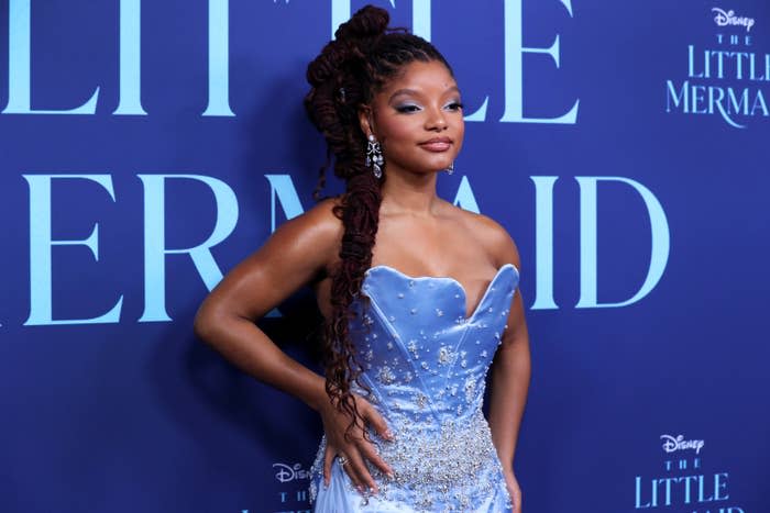 Halle Bailey poses on the red carpet in a strapless mermaid-inspired dress