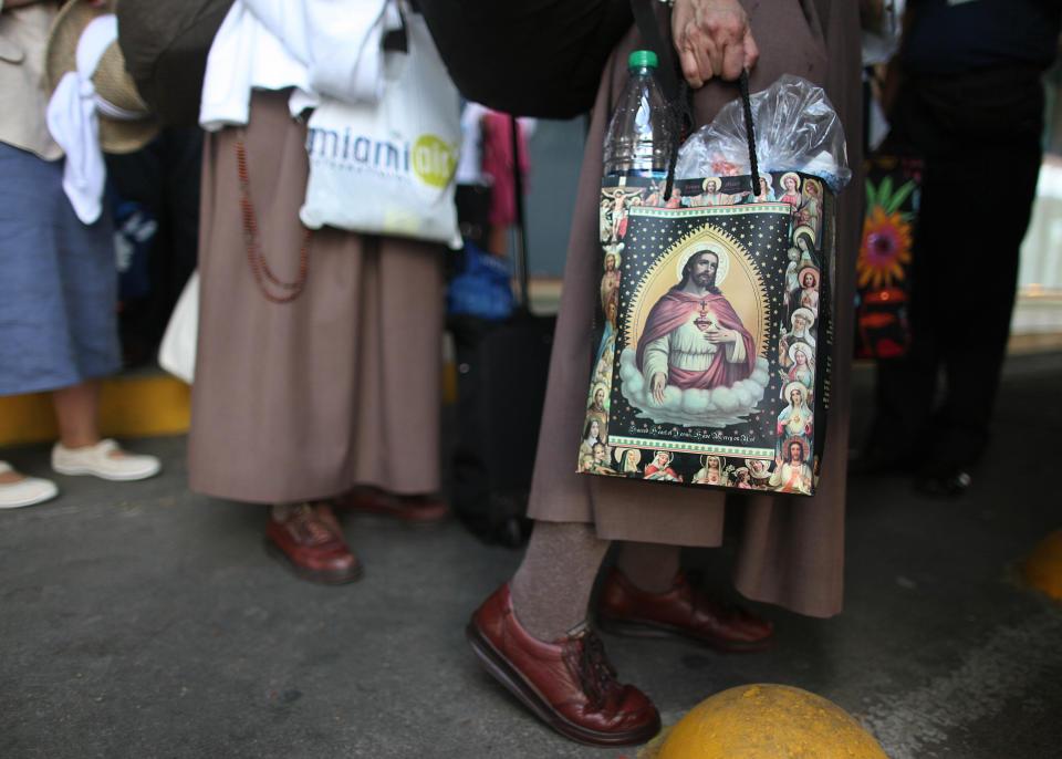 A nun carries a bag covered with an image of Jesus as she arrives with a group of Cuban-Americans at the airport in Santiago de Cuba, Cuba, Monday March 26, 2012. More than 300 Cuban-Americans and other pilgrims have arrived in Cuba for Pope Benedict XVI's visit on a trip led by Miami Archbishop Thomas Wenski. (AP Photo/Esteban Felix)