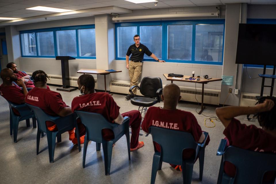 Deputy Nathaniel Minard speaks with a group before leading a one-hour hands-on barber course with a small group of incarcerated men as part of the I.G.N.I.T.E. (Inmate Growth Naturally and Intentionally Through Education) program held in an activities room of the Genesee County Jail in Flint on Thursday, Jan. 4, 2024. "We had a lot of people that were interested. A lot of people that were serious but all the ones in the class really had good interviews. They were really passionate and wanting to do something more with themselves," said Minard.