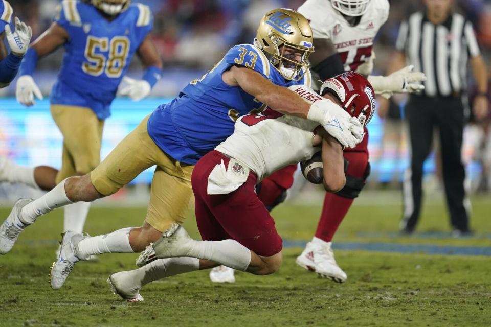 UCLA linebacker Bo Calvert sacks Fresno State quarterback Jake Haener during a game in September 2021.