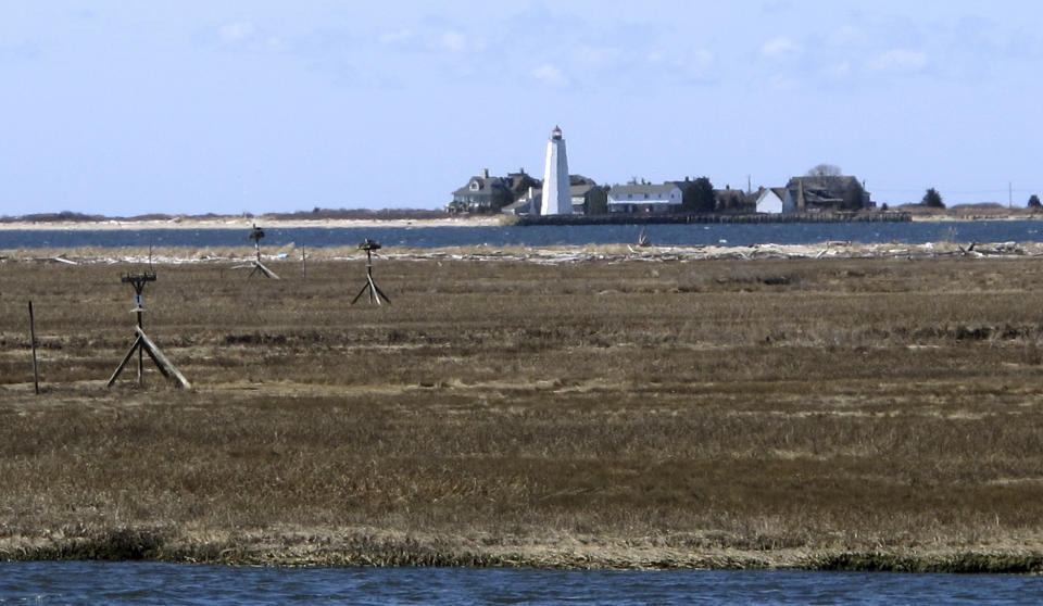 In this April 2, 2019 photo, multimillion-dollar homes and a lighthouse sit on a peninsula in Old Saybrook, Conn. The homes are among more than 900 structures on the East Coast that would become newly eligible for federal disaster aid, under a proposed remapping of coastal protection zones by the U.S. Fish & Wildlife Service (AP Photo/Dave Collins)