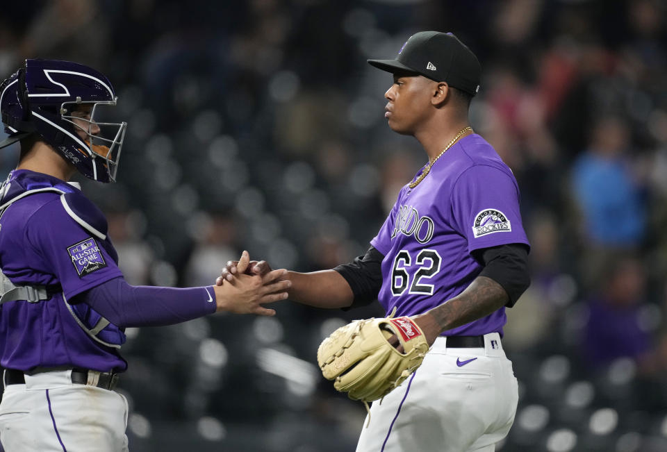 Colorado Rockies catcher Dom Nunez, left, congratulates relief pitcher Yency Almonte after he retired the Arizona Diamondbacks in the ninth inning of a baseball game Friday, May 21, 2021, in Denver. (AP Photo/David Zalubowski)