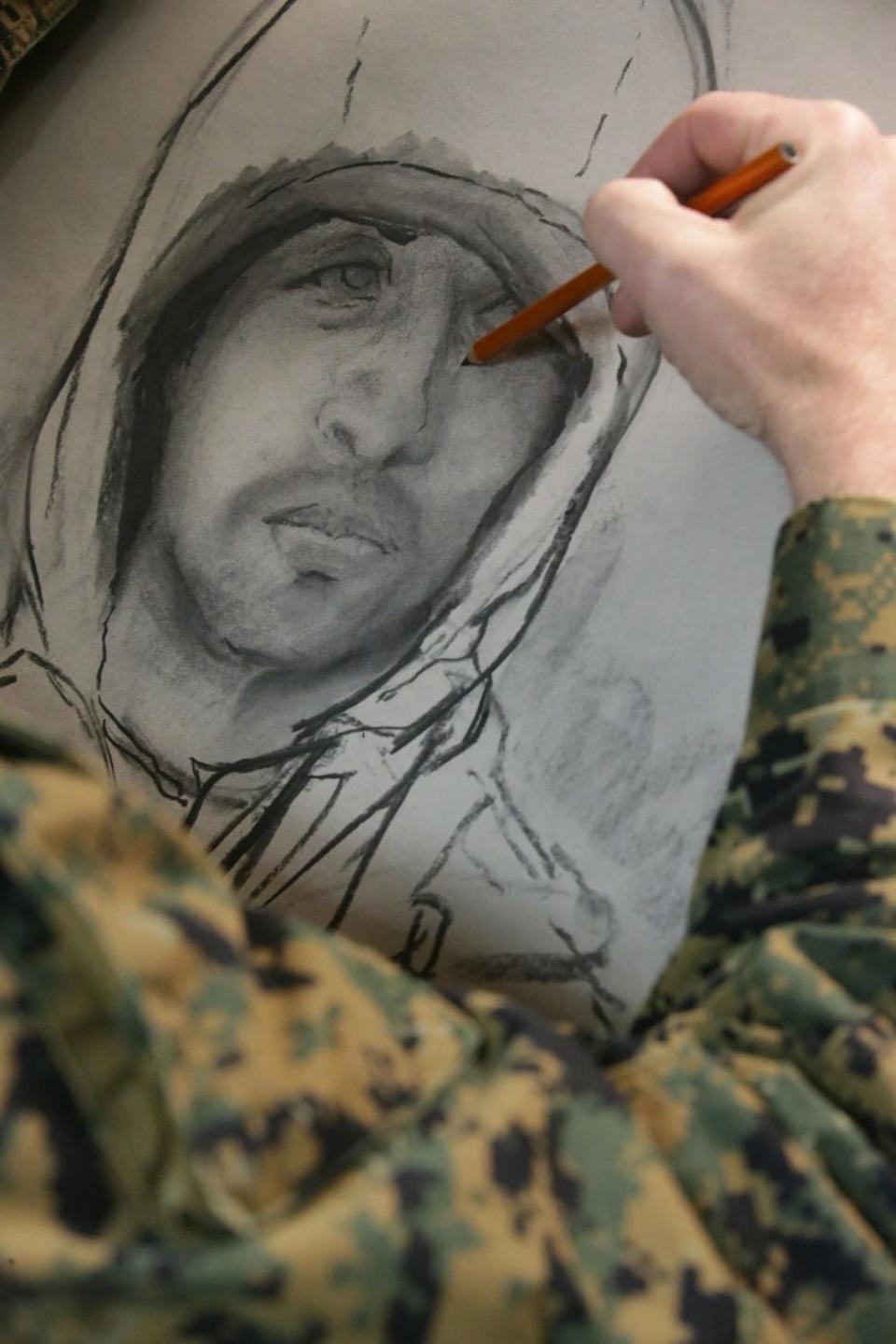 US Marine Corps Maj. Michael Reynolds and a combat artist finish a drawing