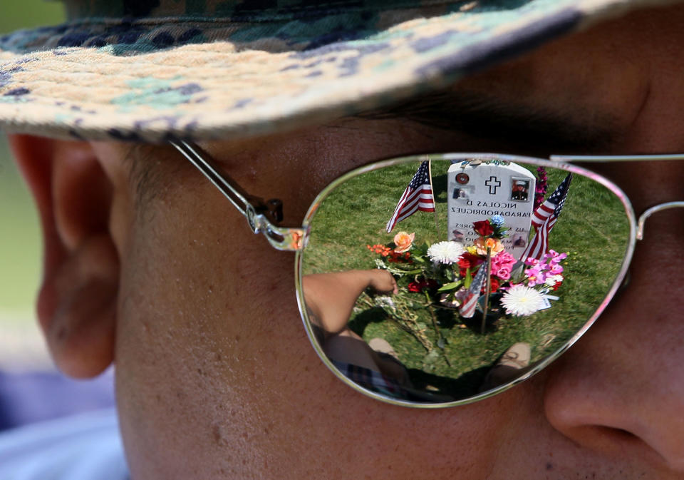 Ricky Parada sits at the grave of his little brother Cpl. Nicolas D. Parada Rodriguez, who was killed in Afghanistan,&nbsp;on Memorial Day at Arlington National Cemetery on May 28, 2012, in Arlington, Virginia.