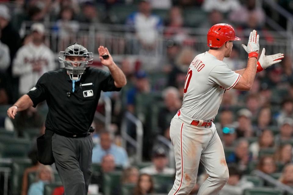 Philadelphia Phillies catcher J.T. Realmuto (10) reacts to advancing to first on a catcher interference call against the Atlanta Braves during the eighth inning of Game 1 of a baseball NL Division Series, Saturday, Oct. 7, 2023, in Atlanta. (AP Photo/Brynn Anderson)