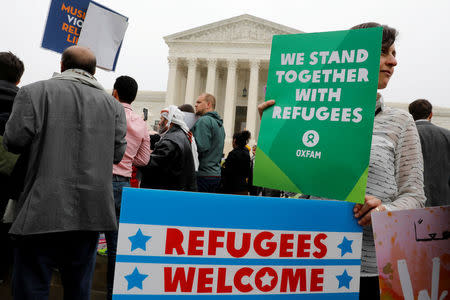 Protesters gather outside the U.S. Supreme Court, while the court justices consider case regarding presidential powers as it weighs the legality of President Donald Trump's latest travel ban targeting people from Muslim-majority countries, in Washington, DC, U.S., April 25, 2018. REUTERS/Yuri Gripas