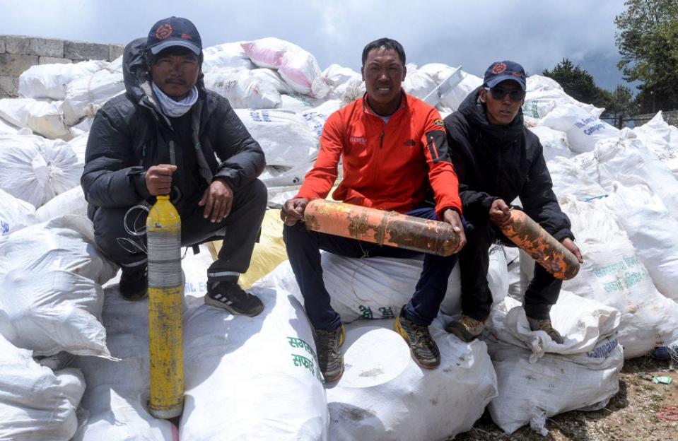 Nepalesische Bergsteiger halten ausrangierte Sauerstoffflaschen, die sie 2019 am Mount Everest gesammelt haben. - Copyright: PRAKASH MATHEMA/Getty Images