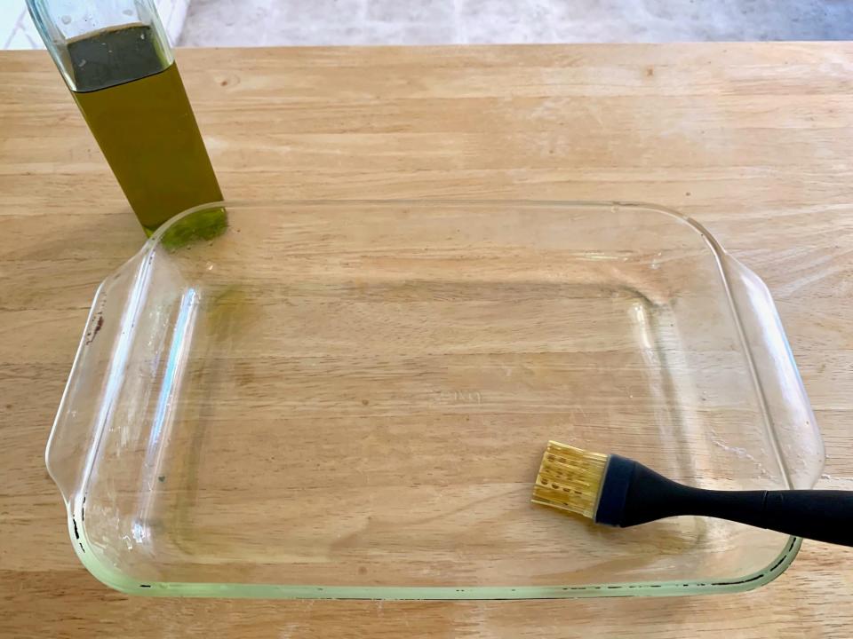 Olive oil with brush in a glass baking dish